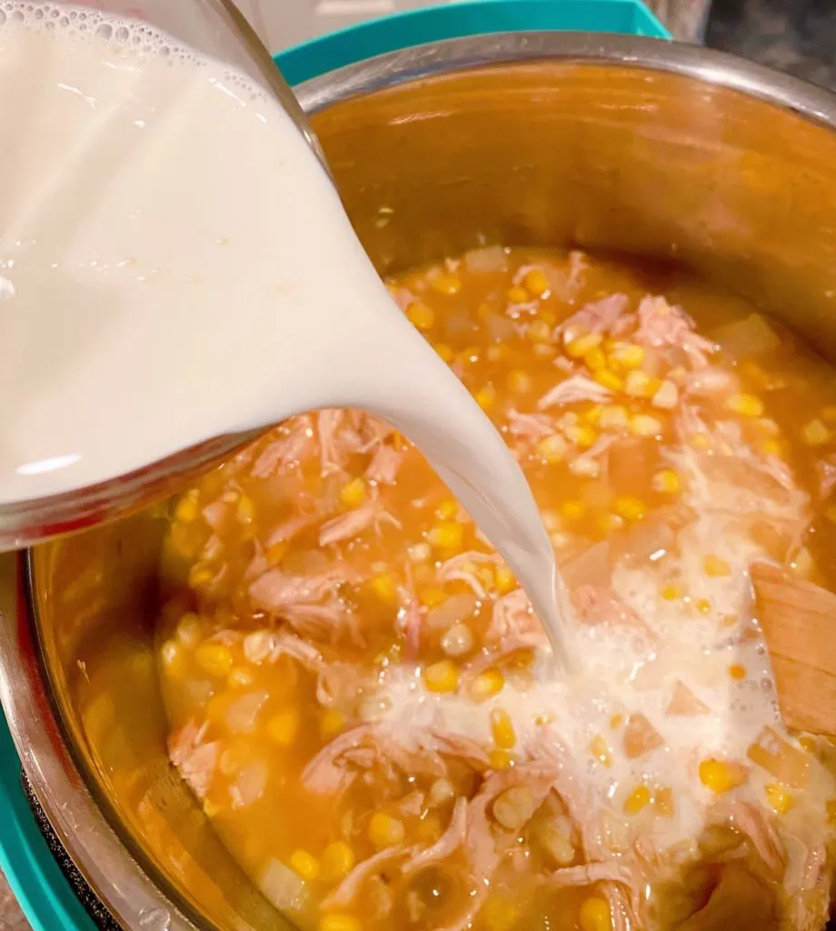 Adding Cream to Corn Chowder in the Instant Pot.