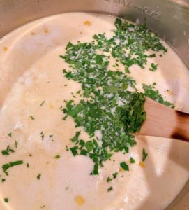 Adding fresh chopped cilantro to soup.