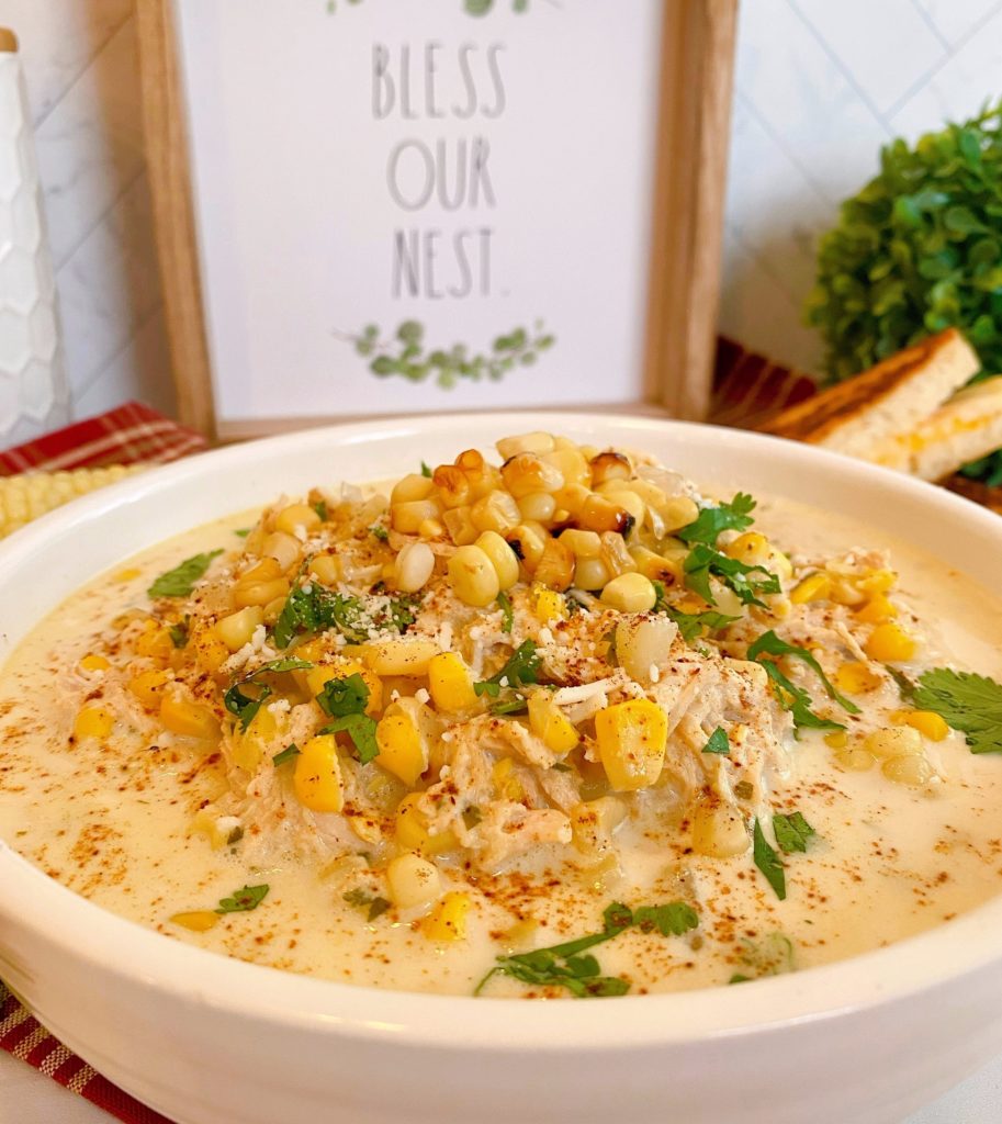 Bowl full of Mexican Chicken Corn Chowder topped with roasted corn, cheese, and cilantro.