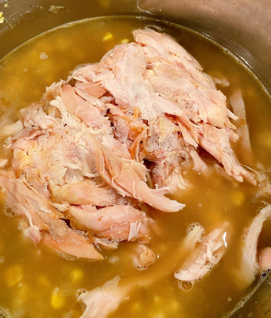 Adding Frozen Rotisserie chicken to corn chowder.