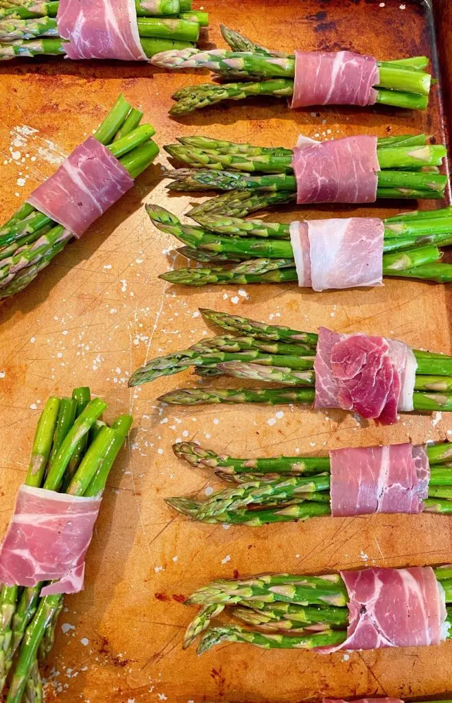 Baking pan with wrapped prosciutto asparagus bundles ready for roasting.