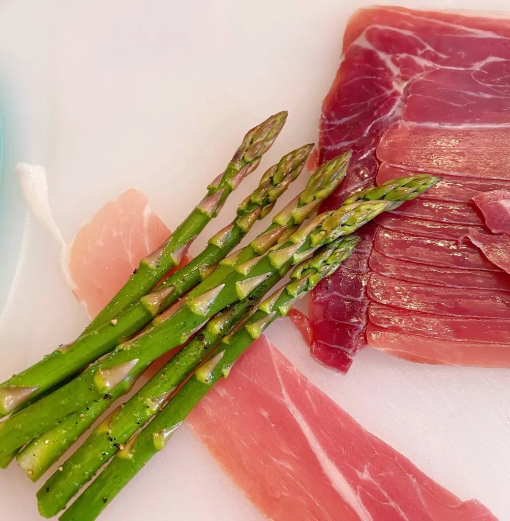 Wrapping asparagus spears in prosciutto.