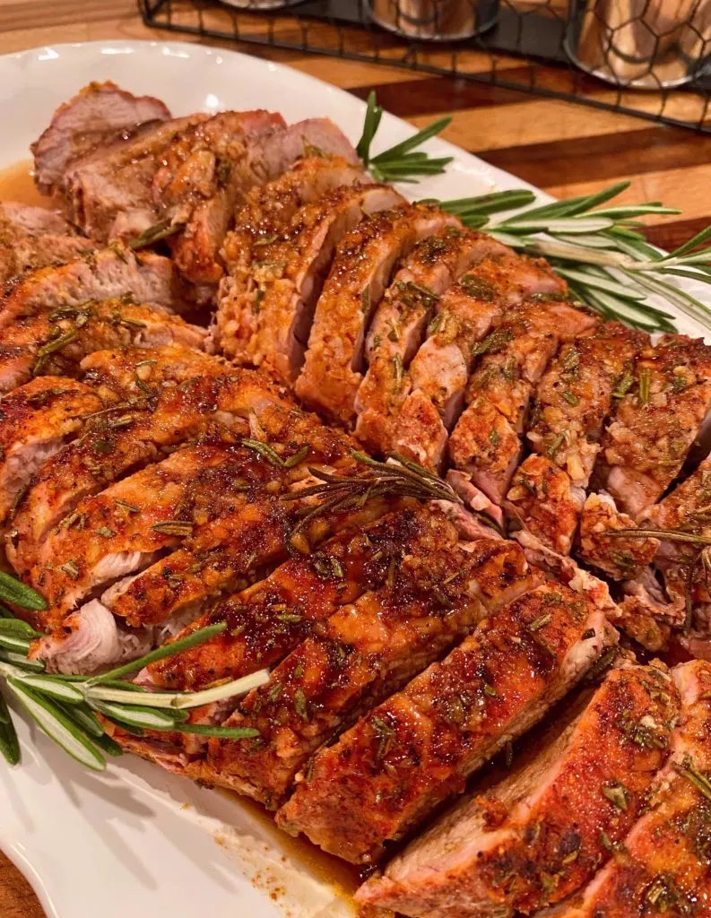 Herbed Pork Tenderloins on a white plater with balsamic glaze.