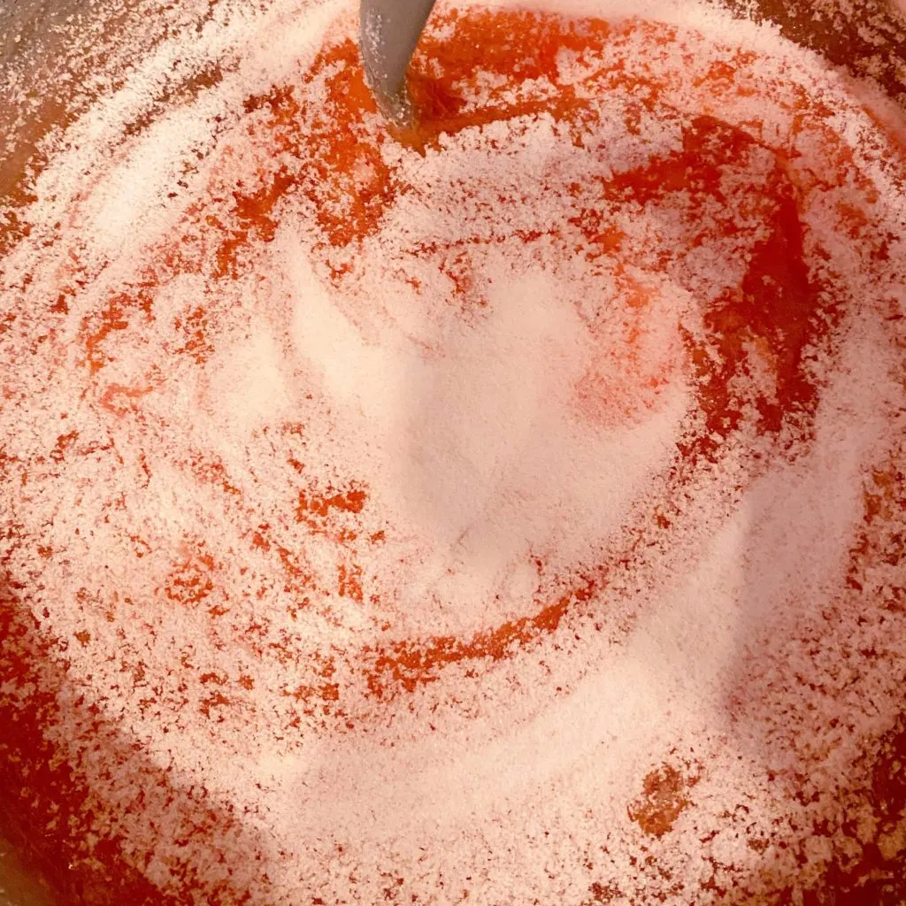Adding gelatin to thickened gel mixture in sauce pan.