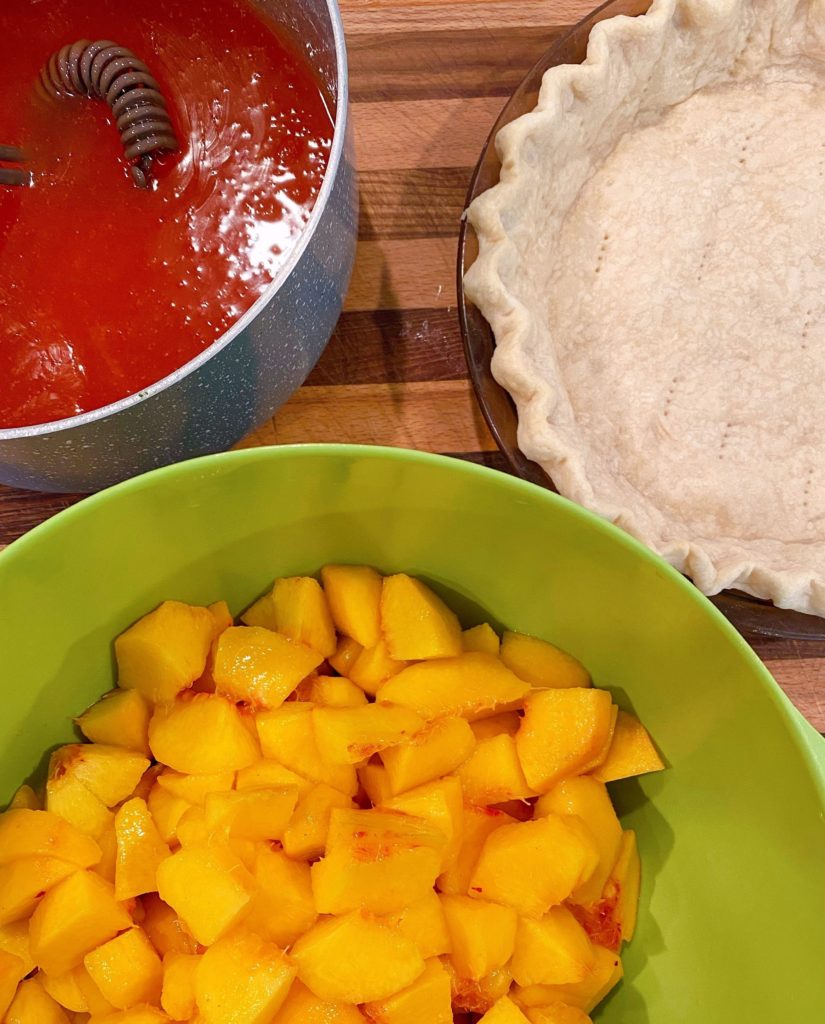 Pie Crust, Glaze, and Peaches on the counter ready to combine to create Fresh Peach Pie.l