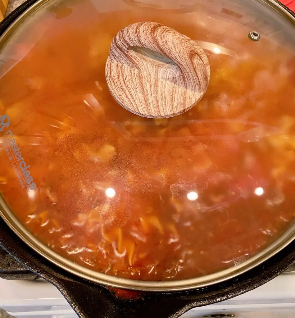 Skillet covered with lid so pasta can cook.