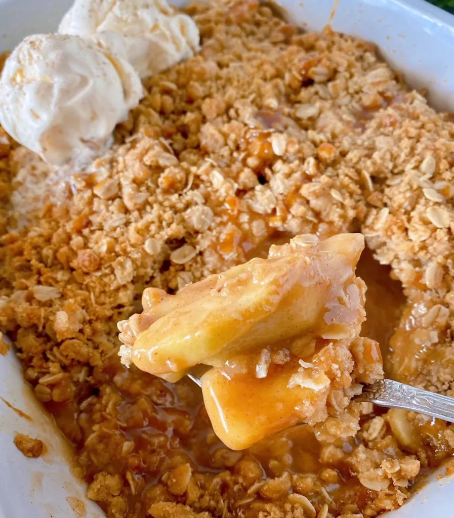 Apples from Apple Crisp speared on a fork after baking straight out of the casserole dish.