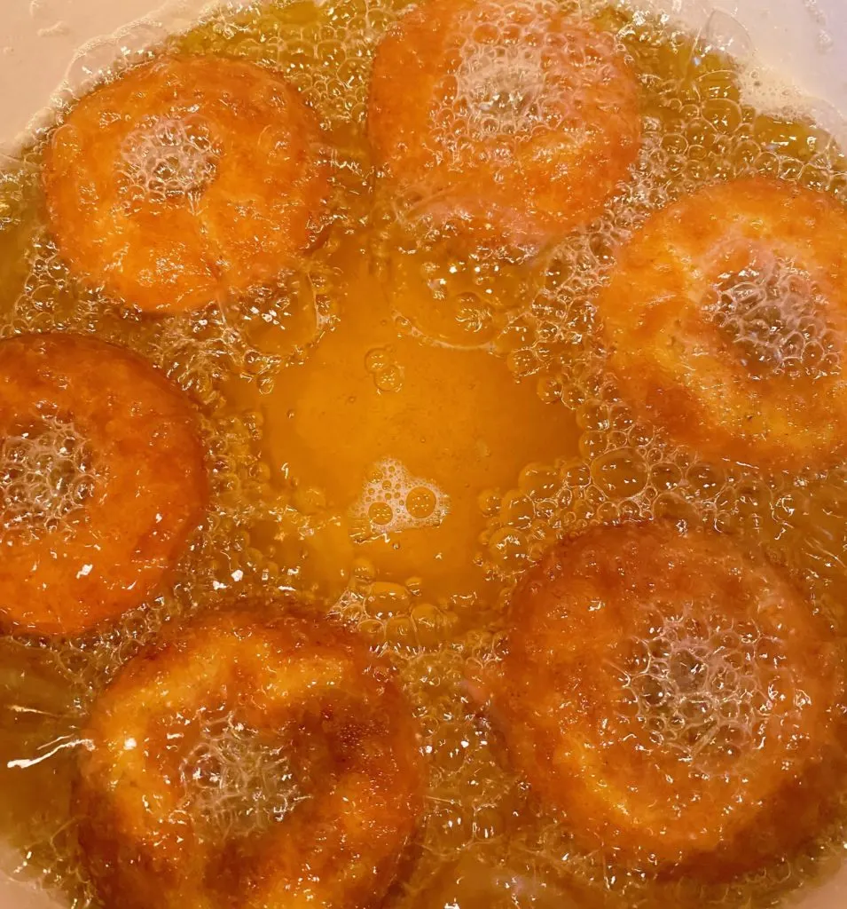 Frying donuts in dutch oven on the stove top.