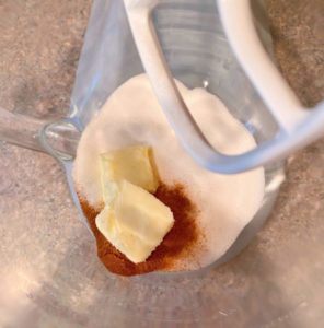 Sugar and butter in mixing bowl of electric mixer.