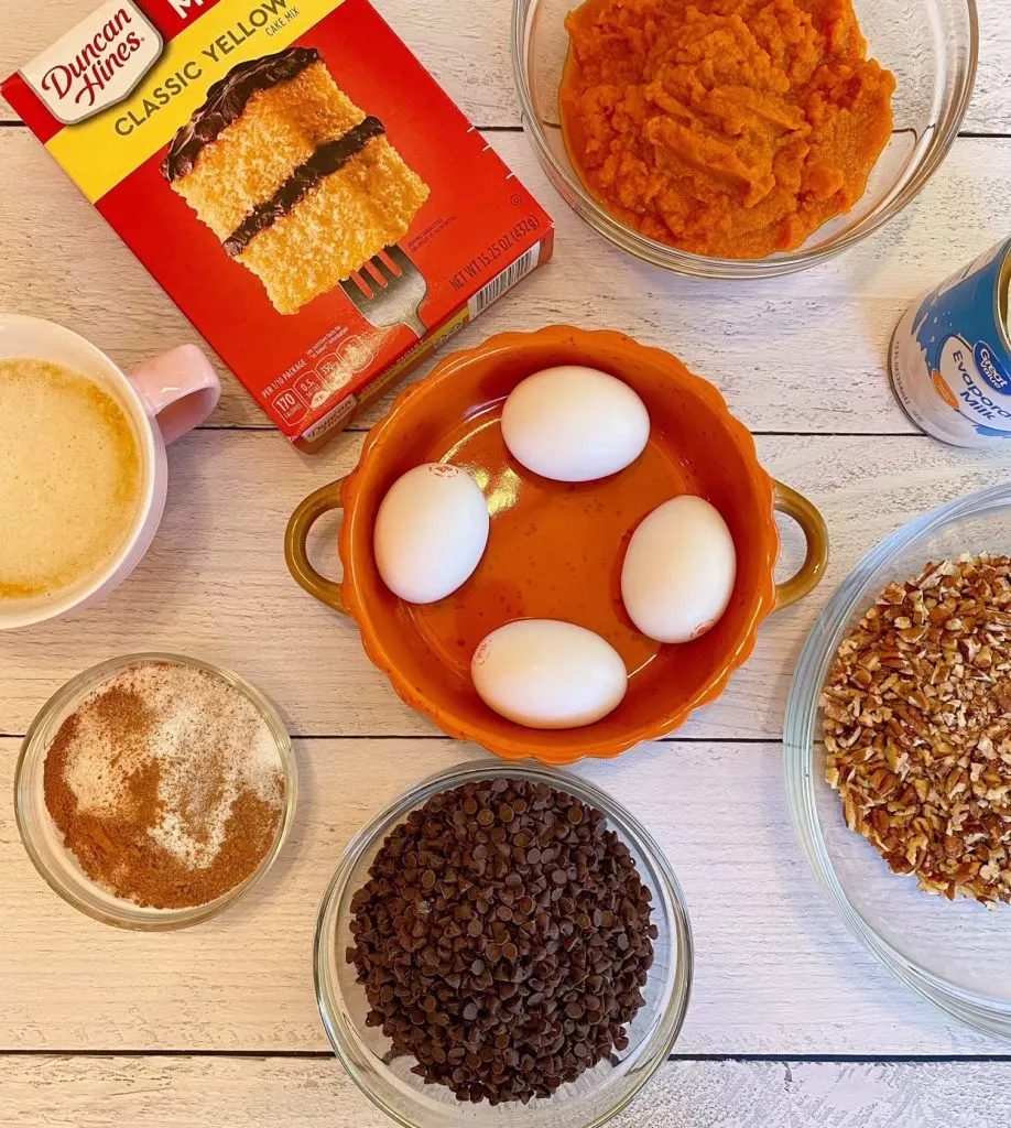 Pumpkin Dump Cake ingredients on white counter tip.