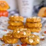Stacks of Pumpkin White Chocolate Macadamia Nut Cookies on a Fall piece of paper.n