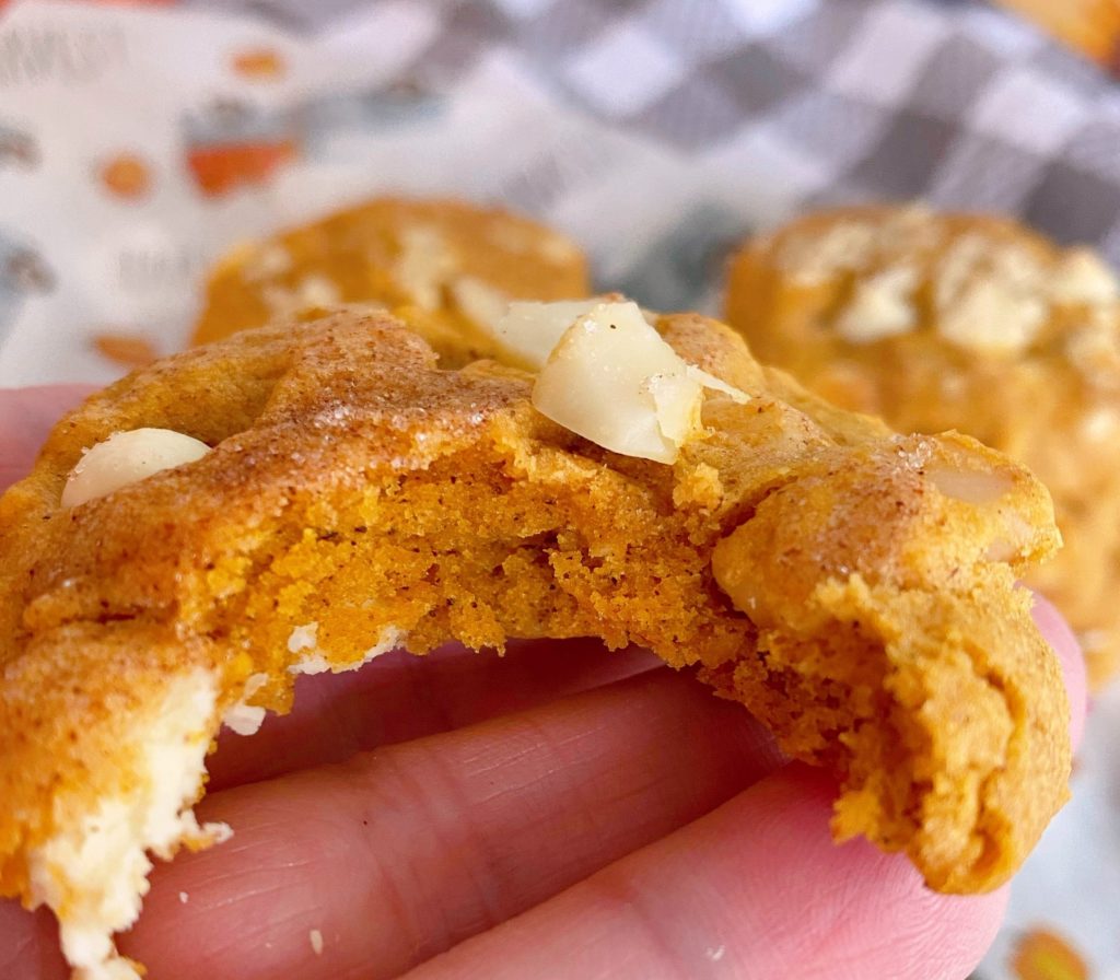 Norine holding a cookie with a bite out of it. 