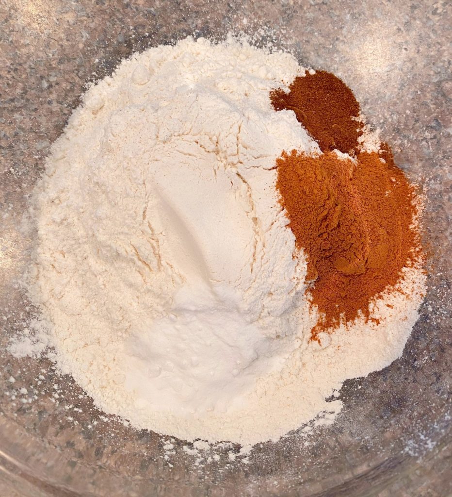 Flour, cinnamon, cloves, and baking soda in a small bowl.