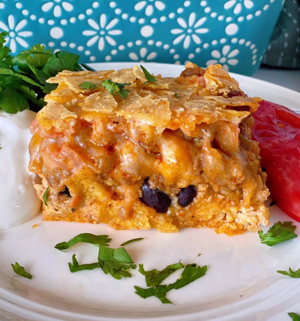 Breakfast Ranchero Egg Bake Casserole serving on white plate with cilantro.