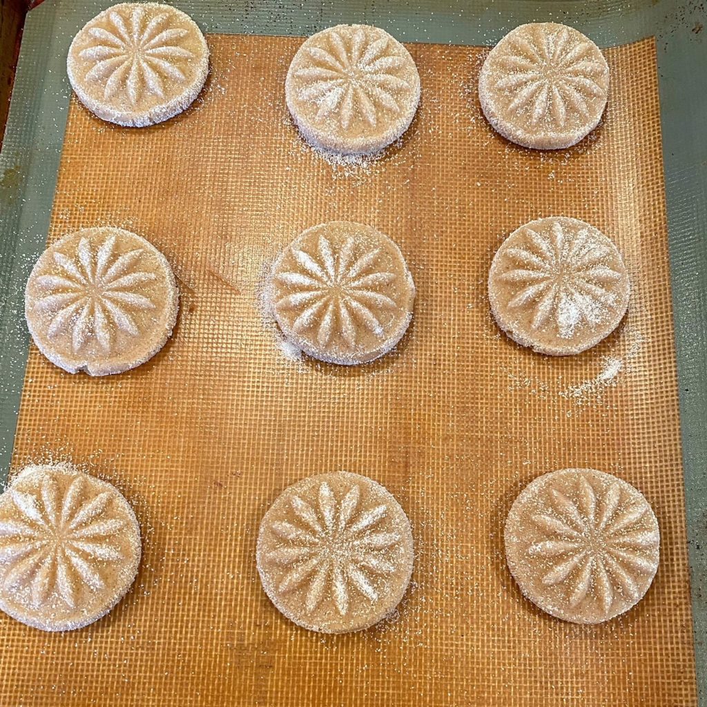 Pressed cookies on a baking sheet ready to bake.