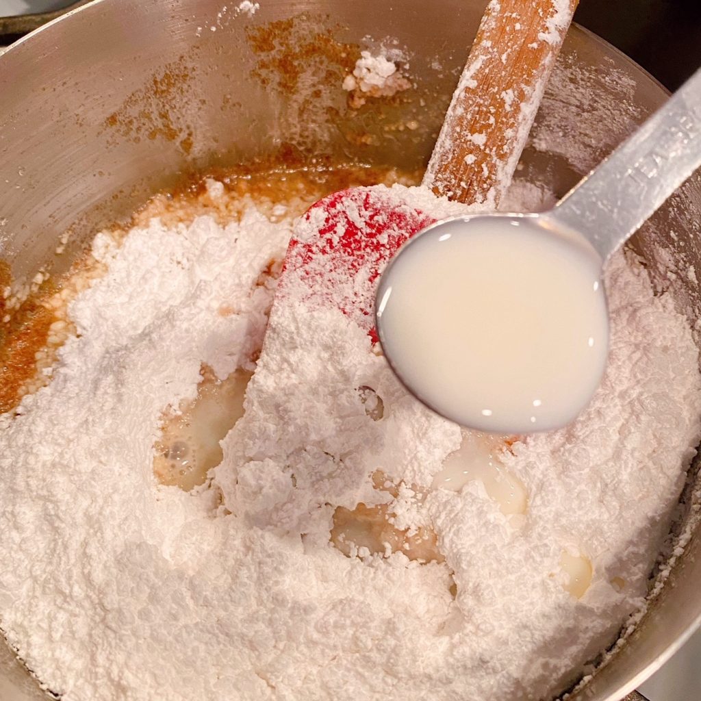 Adding powder sugar, vanilla, and milk into creamy filling.