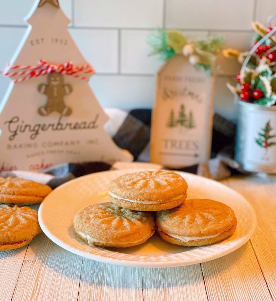 Cardamom Print Sandwich Cookies on a plate with Christmas decor in the background.