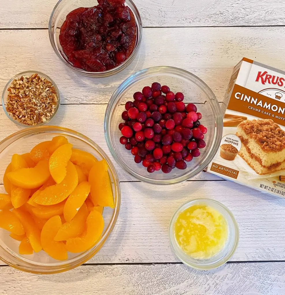 Ingredients for Peach Cranberry Cobbler on a white board.