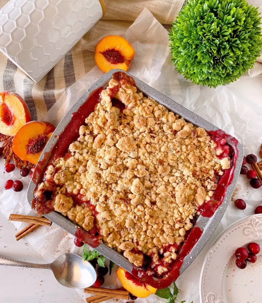 Baked Peach and Cranberry Cobbler on table.