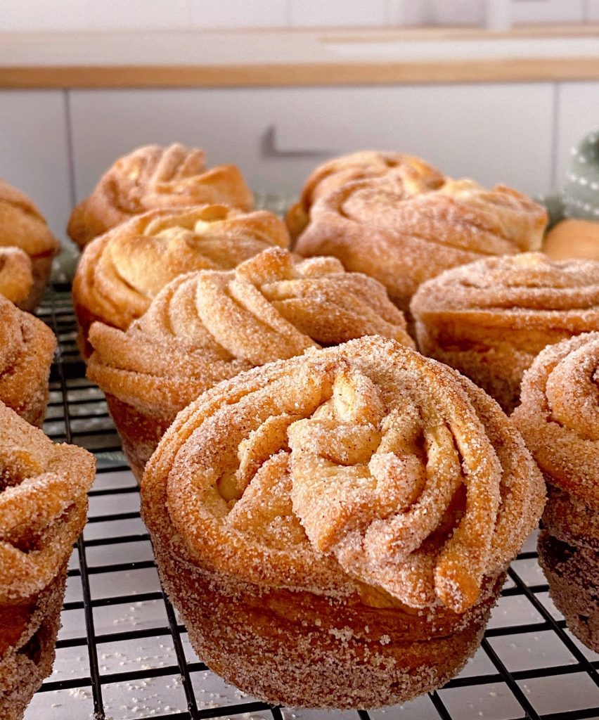 Close-up photo of Cruffins on a baking rack cooling.