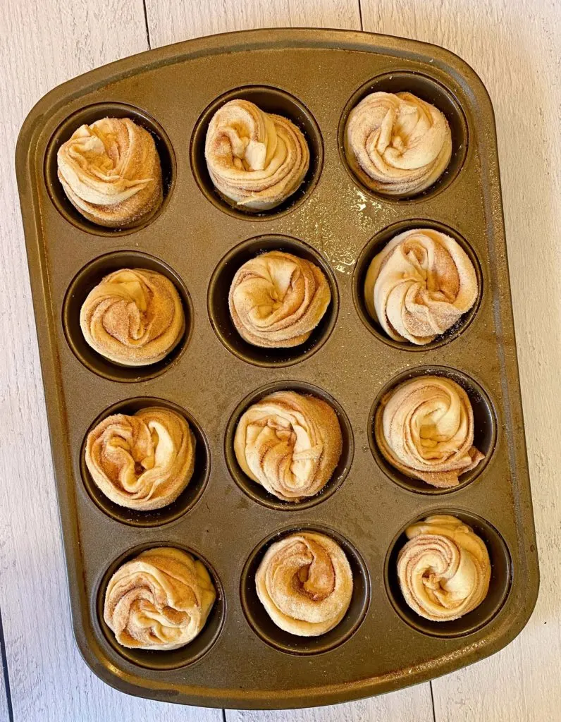 Cruffins in muffin tin ready to bake.
