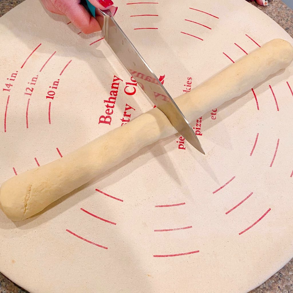 Cutting crescent dough log in half.