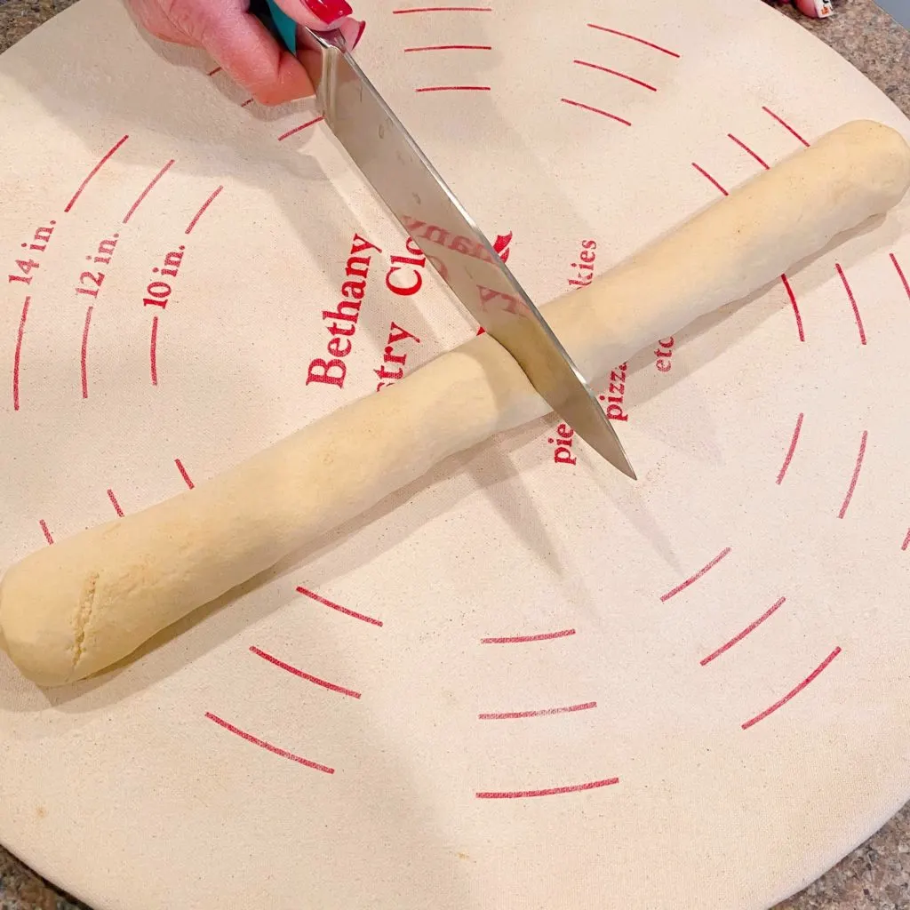 Cutting crescent dough log in half.