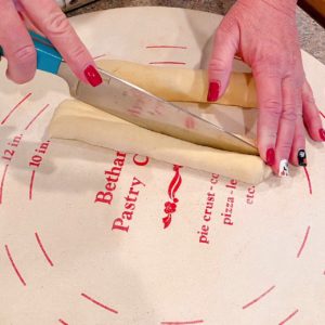 Cutting dough into half lengthwise.