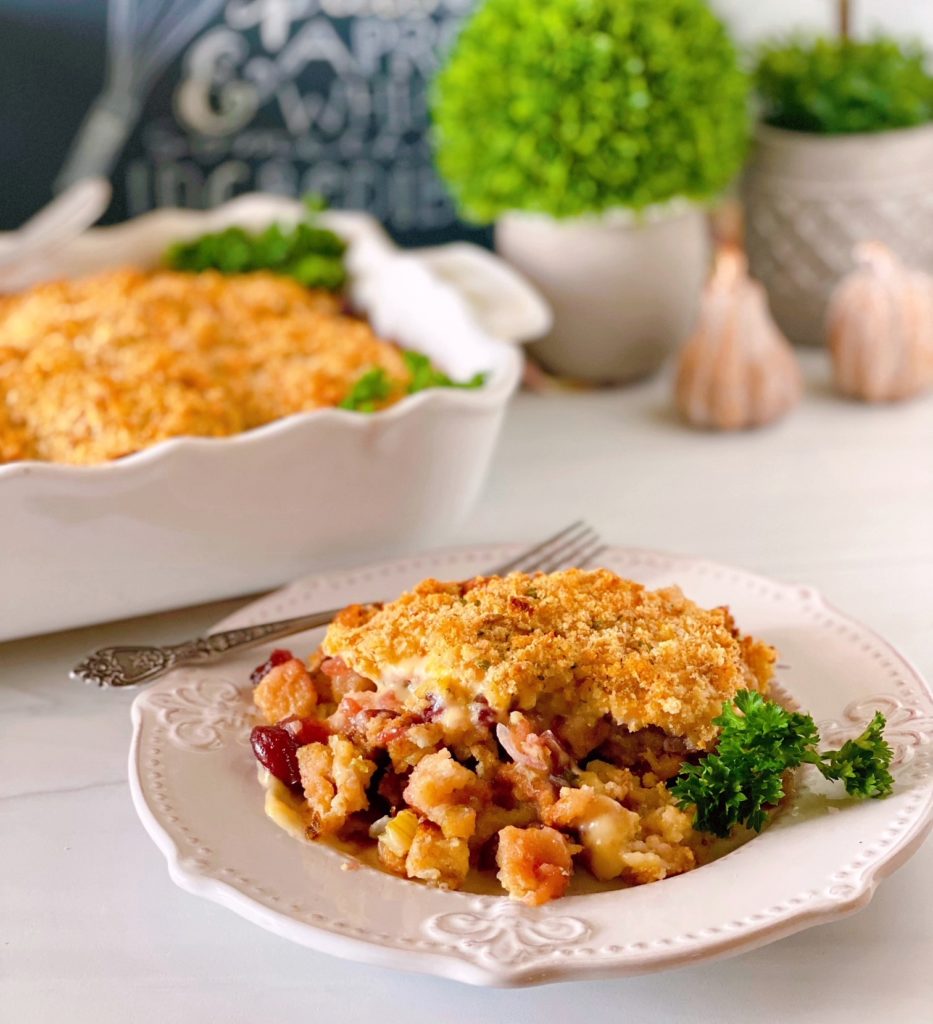 Turkey Cutlet, Stuffing, and Cranberry Casserole in the background and in the foreground a serving of the casserole in front.