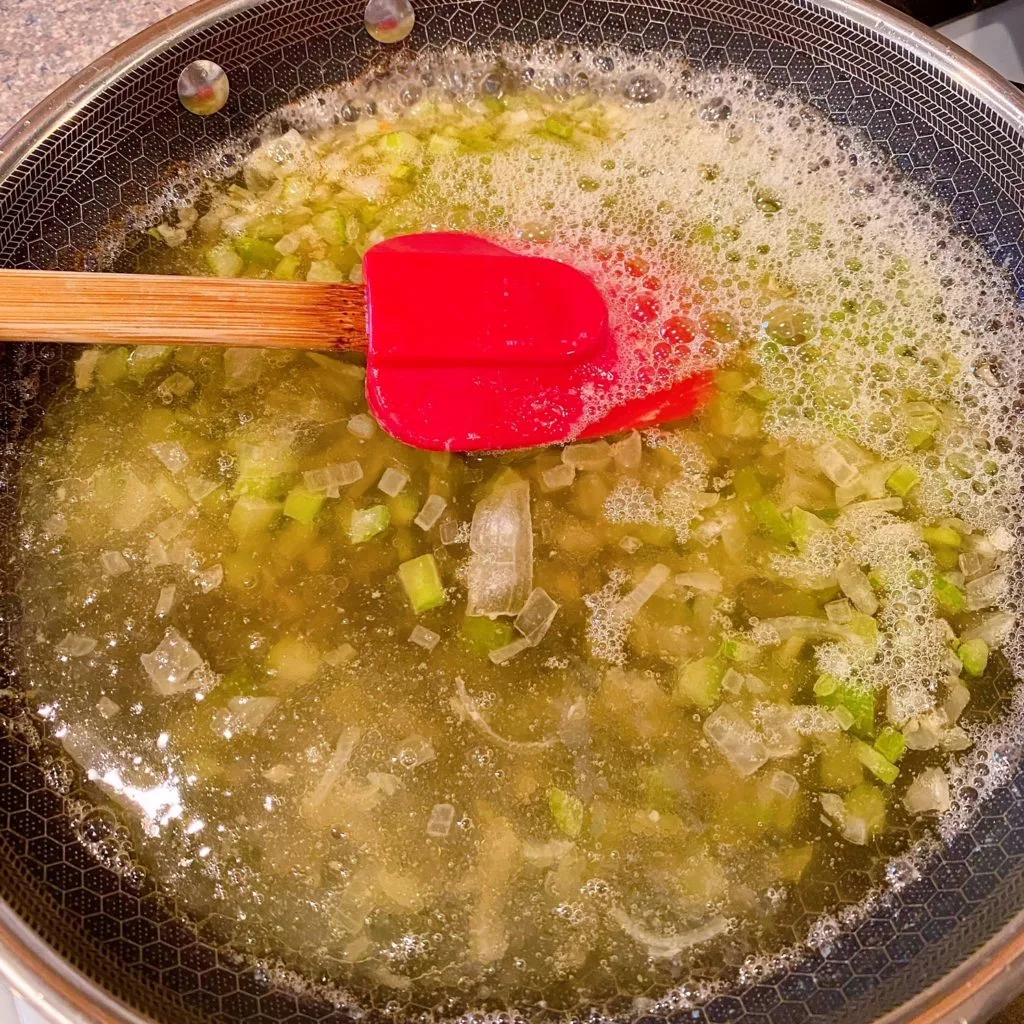 Adding broth to celery and onions. Bringing to a boil.