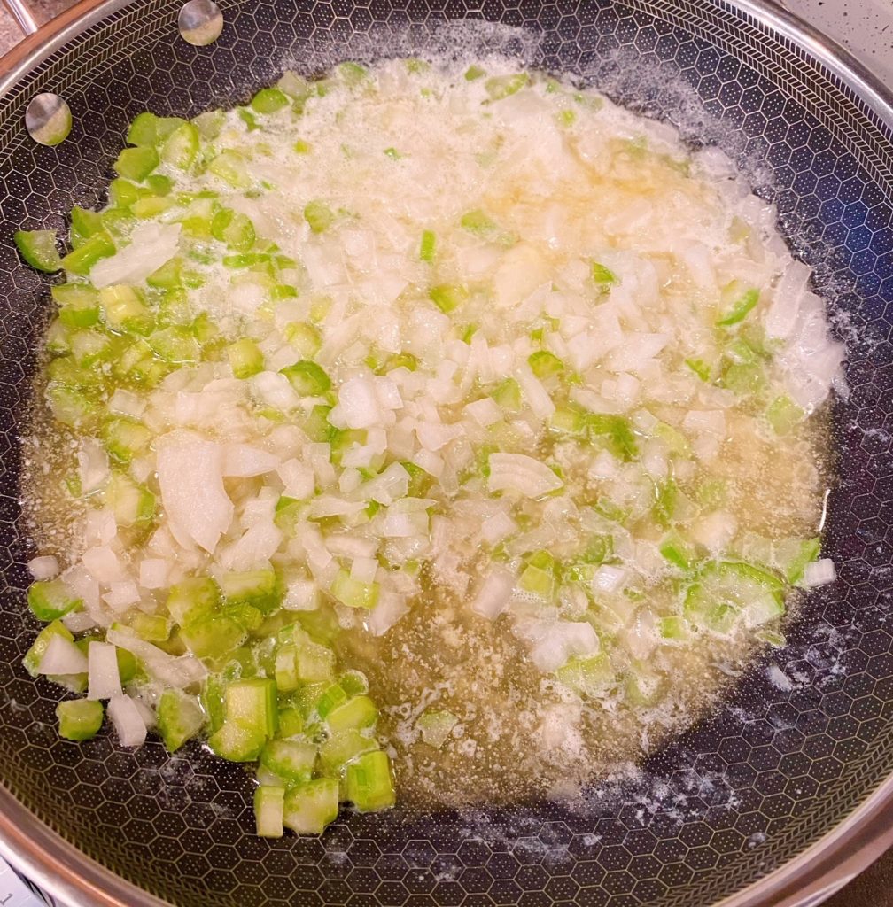 Onion and Celery sauteing in a large skillet.