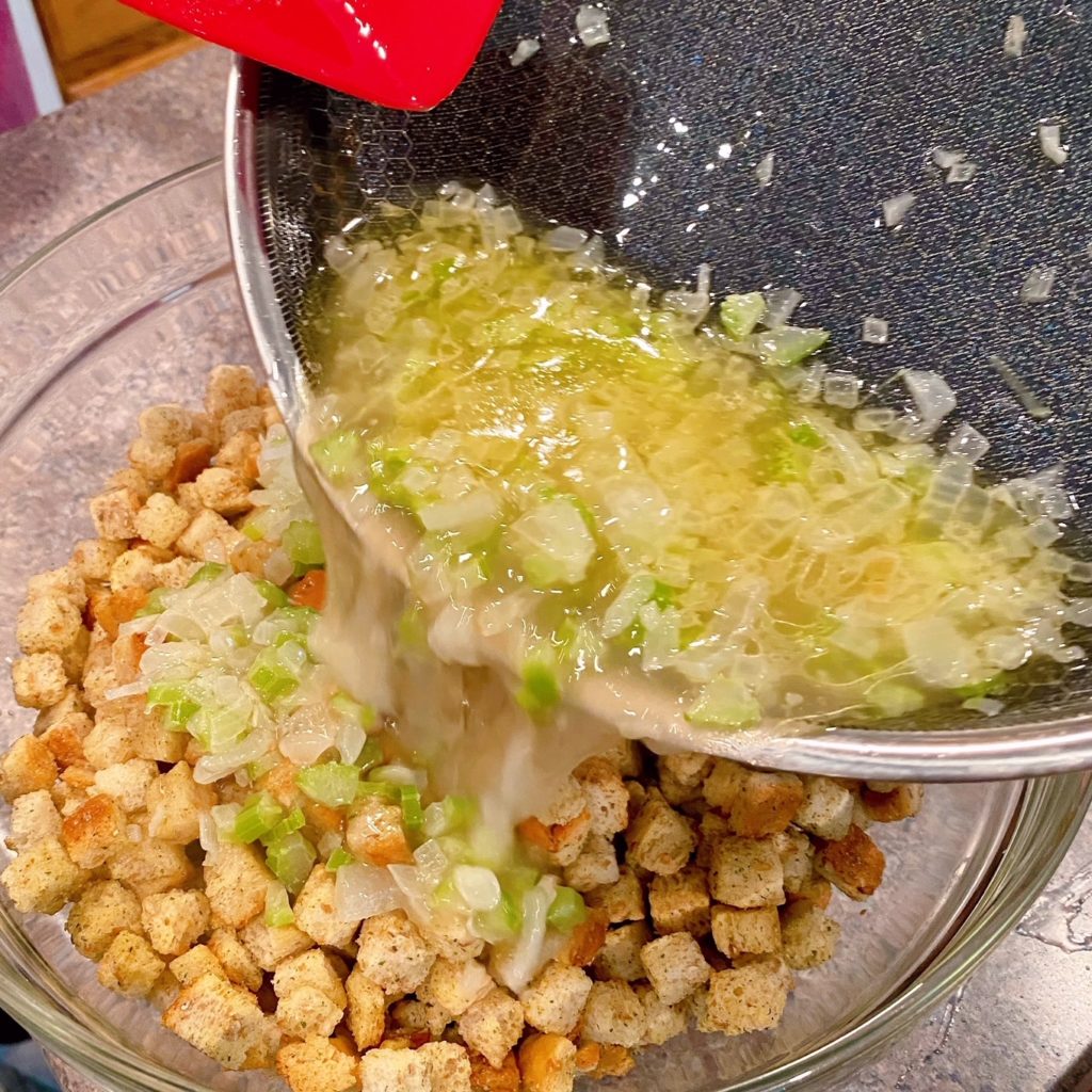 Adding stuffing to celery and onion mixture.