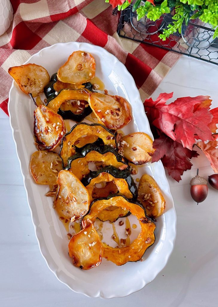 Roasted Acorn Squash with Pears on a long platter sprinkled with pecans.