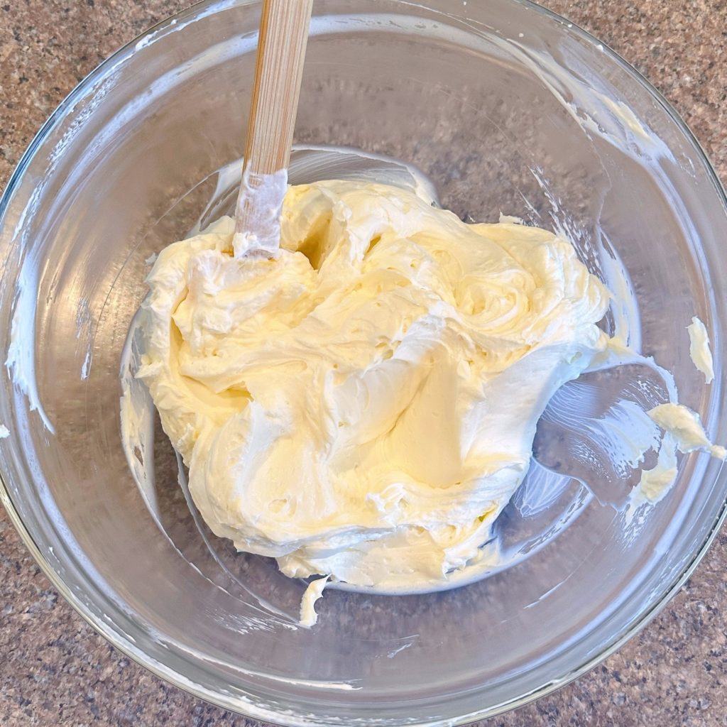 Adding lemon zest and lemon juice to whipped cream cheese filling.