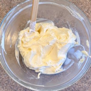 Adding lemon zest and lemon juice to whipped cream cheese filling.