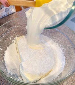 Adding Whipped cream to cream cheese and powder sugar.
