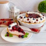 Cranberry Blueberry Cream Cheese Pie slice on a white plate with whole pie in the background.