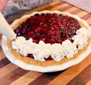 Pipping Whipped Cream garnish around the edge of the pie.