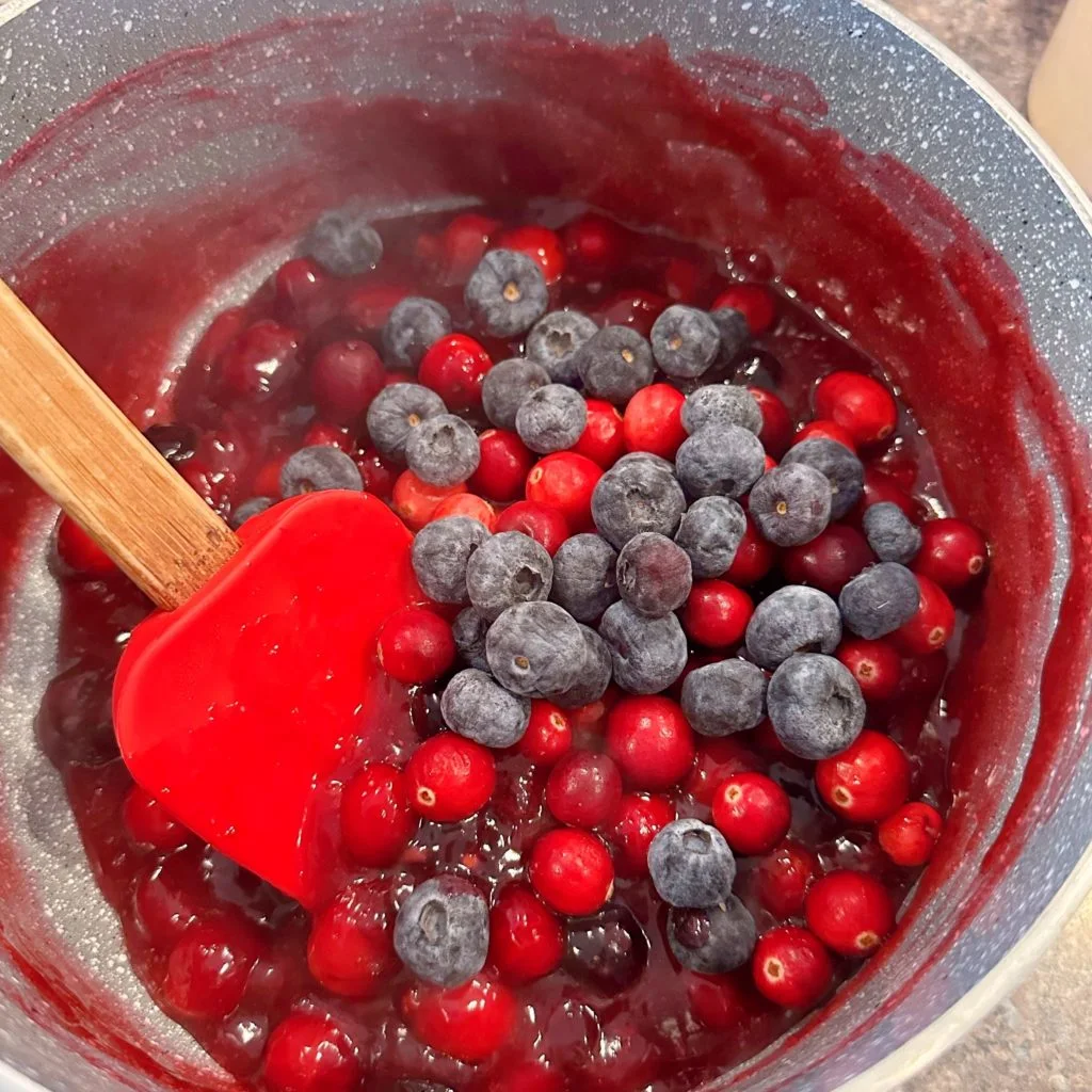 Adding additional fruit to the fruit topping mixture after it has cooked.