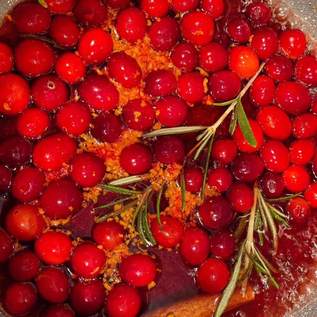 Cranberry Sauce in a sauce pan boiling on the stove top.