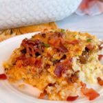 White plate with a serving of Loaded tater tot breakfast casserole on the plate.