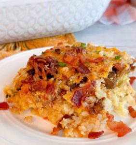 White plate with a serving of Loaded tater tot breakfast casserole on the plate.