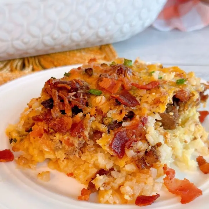 White plate with a serving of Loaded tater tot breakfast casserole on the plate.