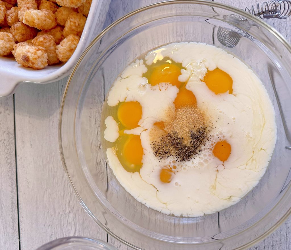 Adding seasoning to eggs and milk in mixing bowl.