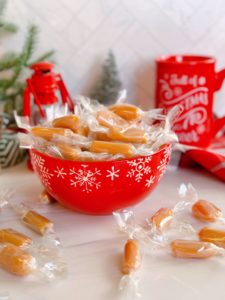 Homemade Caramels wrapped and in a red candy dish.