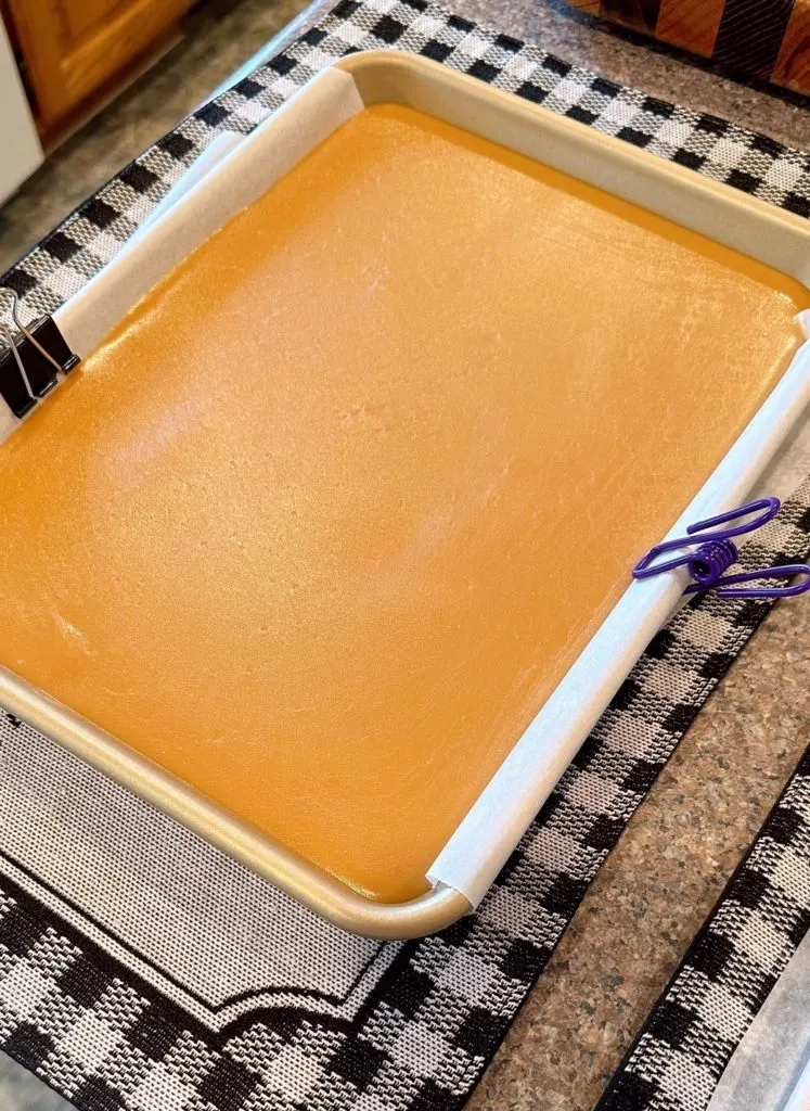 Caramel poured into lined baking sheet cooling.