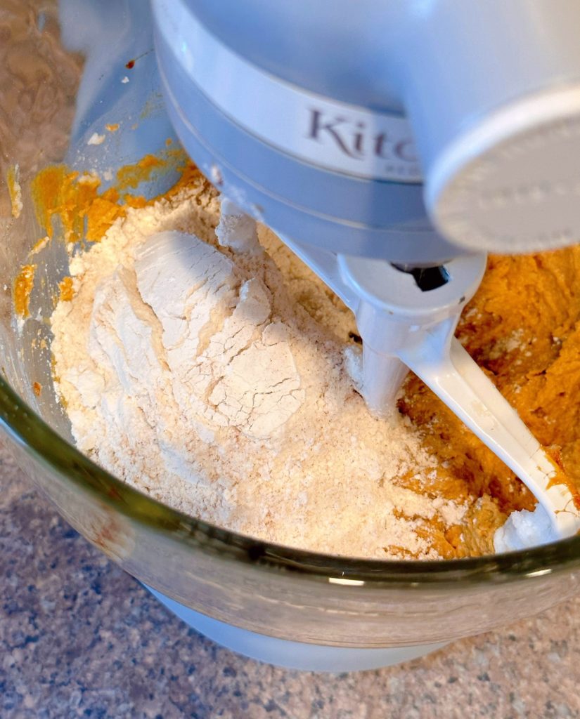 Adding dry ingredients to creamed ingredients.