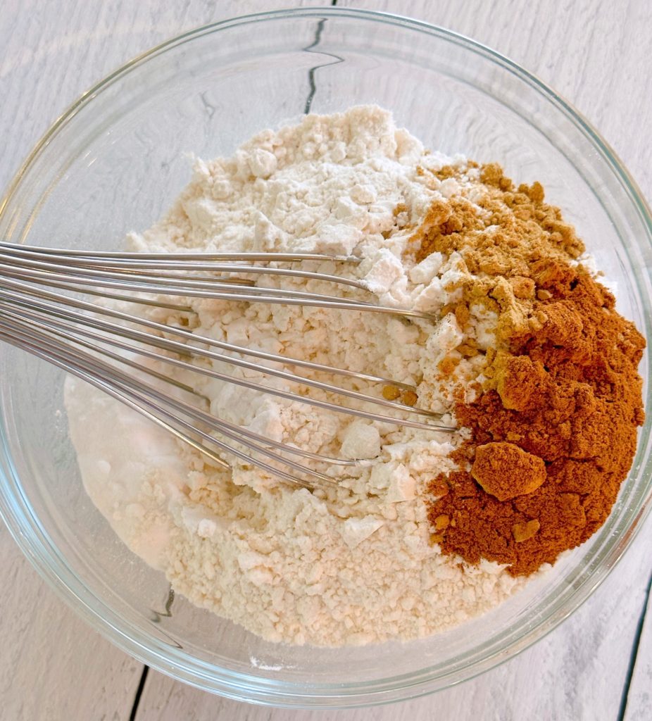 Combining dry ingredients in a large bowl for Molasses Cookies.