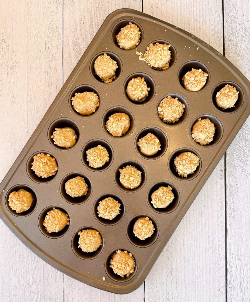 Rolled Peanut Butter Cookie Dough placed in the cups of a mini muffin pan.
