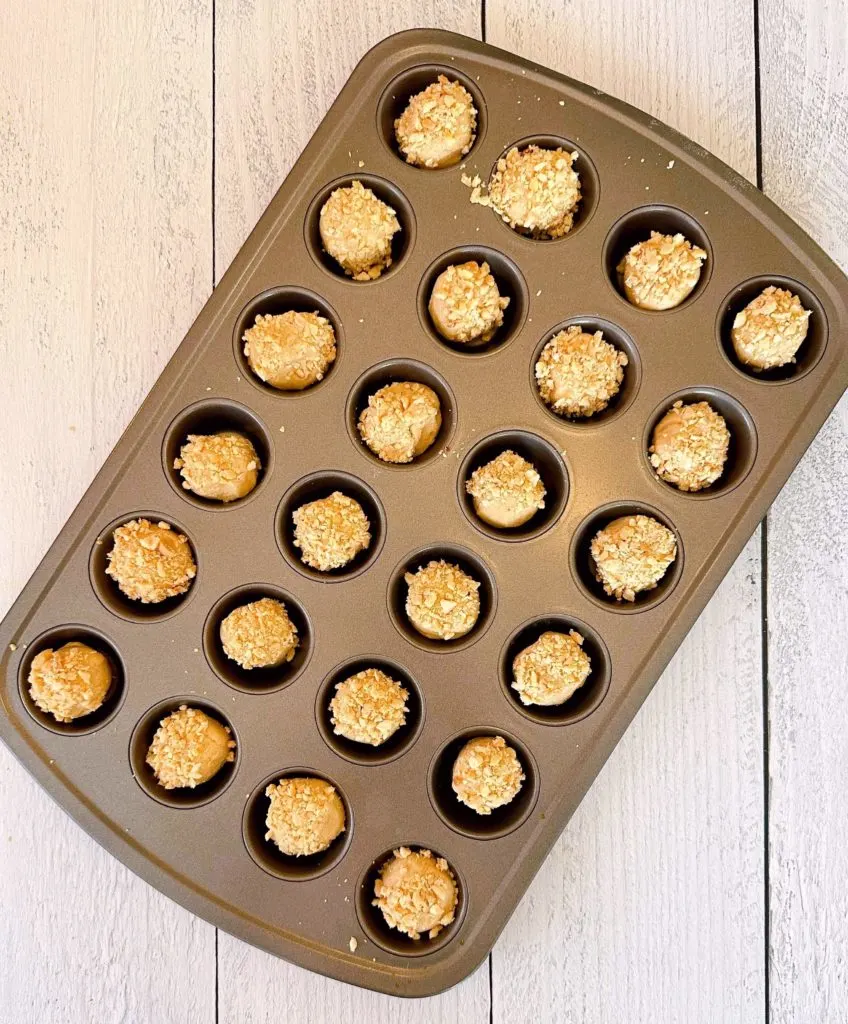 Rolled Peanut Butter Cookie Dough placed in the cups of a mini muffin pan.